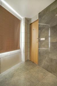 ein Badezimmer mit einer Dusche und einer Holztür in der Unterkunft Hotel Global Inn in Amritsar
