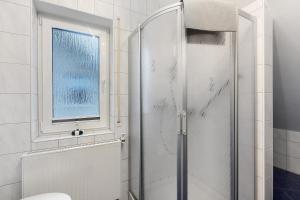 een douche met een glazen deur in een badkamer bij Ferienwohnung Westfeld in Bestwig +13 foto's