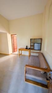 a room with a bed and a table and a tv at Joujo's Jungle Guest House in Nungwi
