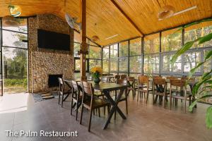 een eetkamer met een tafel en stoelen en een open haard bij TVpalm Ecolodge in Ha Giang