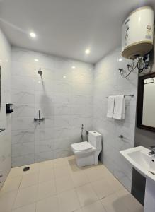 ein weißes Badezimmer mit Toilette und Waschbecken in der Unterkunft Queen Hills Resort and Hotel By Edge Group - Rooftop Restro, Balcony View in Masuri