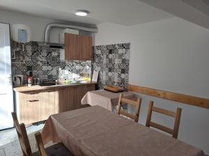 伯伊莱海尔库拉内Vila Ovidiu的厨房配有桌子和两把椅子和一张桌子,厨房配有