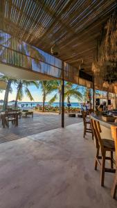 a restaurant on the beach with tables and chairs at Joujo's Jungle Guest House in Nungwi