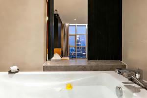 a bathroom with a bath tub with a window at Chongqing IBESHO HOTEL in Chongqing
