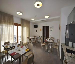 een eetkamer met tafels en stoelen en een televisie bij Cameras Mori in Mori