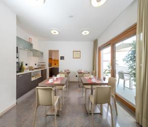 een keuken en eetkamer met tafels en stoelen bij Cameras Mori in Mori