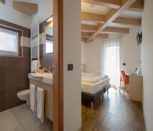 een badkamer met een bed en een wastafel in een kamer bij Cameras Mori in Mori +16 foto's