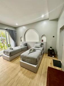 een slaapkamer met twee bedden en een groot raam bij New Mekar Jaya Hotel in Legian