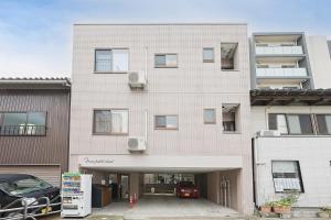 een appartementencomplex met een parkeerplaats ervoor bij Mon Petit Chat in Kanazawa