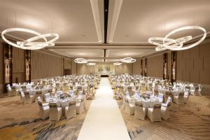une grande salle de banquet avec des tables et des chaises blanches dans l'établissement Hilton Petaling Jaya, à Petaling Jaya 79 autres photos