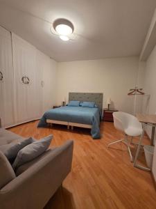 een slaapkamer met een bed, een bank en een tafel bij Mater Domini in Chieti