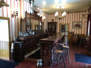 a pub with a bar with stools in a room at Cosmopolitan Hotel in San Diego