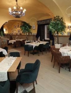 ein Restaurant mit Tischen und Stühlen und einem Kronleuchter in der Unterkunft Hotel Leopold I in Novi Sad