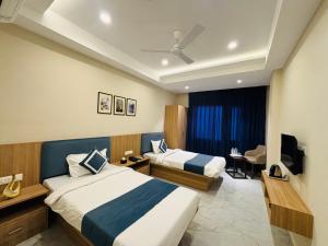 a hotel room with two beds and a television at MG Plaza Hotel in Jodhpur