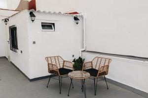 two chairs and a table in front of a building at Domus Mare in Peñíscola