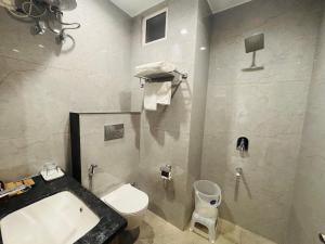 a bathroom with a white toilet and a sink at MG Plaza Hotel in Jodhpur +22 photos