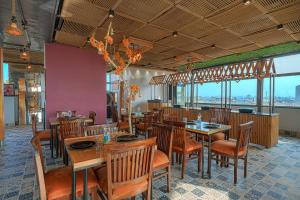 a restaurant with wooden tables and chairs and windows at Hotel Global Inn - Few steps walk to Golden Temple in Amritsar
