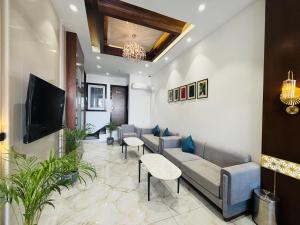 a living room with a couch and a tv at MG Plaza Hotel in Jodhpur