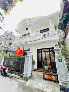 a white house with a scooter parked in front of it at SAM HOUSE 2 Huế in Cồn Giả Viên +6 photos