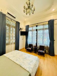 a bedroom with a bed and a chandelier at SAM HOUSE 2 Huế in Cồn Giả Viên