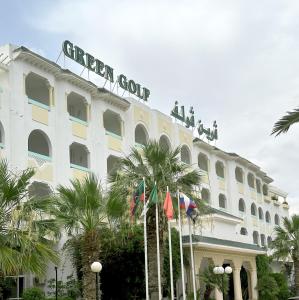 Un edificio bianco con persone sedute sopra di esso di Green Golf Hammamet a Hammamet