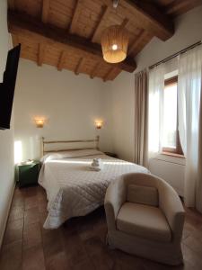 een slaapkamer met een bed en een stoel bij Il Casale Naturart in Lucciano