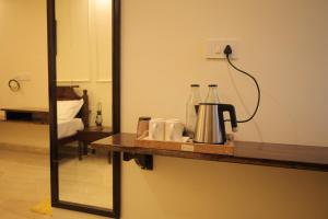 eine Theke mit Kaffeemaschine und Spiegel in der Unterkunft Chandra Bagh in Māvli