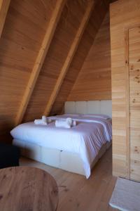 een slaapkamer met een wit bed op zolder bij United Villas in Pogradec