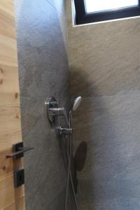 een douche in een badkamer met een douchekop bij United Villas in Pogradec +44 foto's