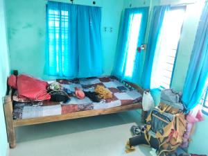 a bedroom with a bed with blue walls and blue curtains at Lakecampers for foreign travellers in Alleppey +17 photos