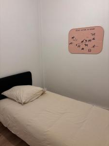een slaapkamer met een bed met een bordje aan de muur bij Le Parisien - Cœur de Saint-Brieuc in Saint-Brieuc +4 foto's
