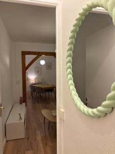 een spiegel aan de muur van een kamer met een tafel bij Le Parisien - Cœur de Saint-Brieuc in Saint-Brieuc