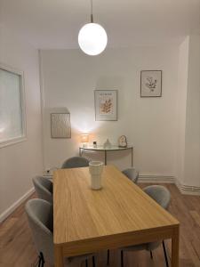 een eetkamer met een houten tafel en stoelen bij Le Parisien - Cœur de Saint-Brieuc in Saint-Brieuc