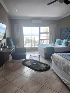 una camera con 2 letti, una scrivania e una TV di BY Guest House a Hartbeespoort