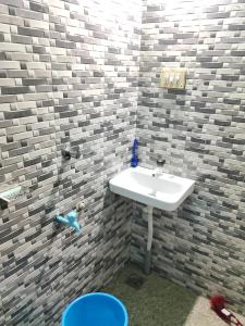 a bathroom with a white sink in a brick wall at Lakecampers for foreign travellers in Alleppey