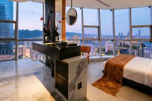 a bedroom with a bed and a desk and windows at Chongqing IBESHO HOTEL in Chongqing