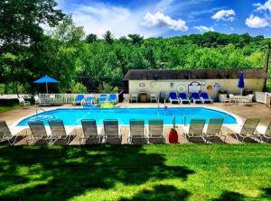 a large swimming pool with chairs and a building at Cove Haven Resort in Lakeville