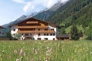 a large building in a field of grass with at Hotel Gsallbach in Kaunertal