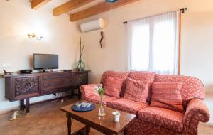 een woonkamer met een rode bank en een tafel bij Villa Sa Mata in Campanet