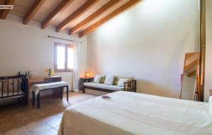 een slaapkamer met een bed, een bank en een tafel bij Villa Sa Mata in Campanet +39 foto's