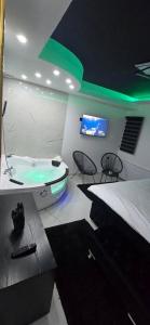 een kamer met een bad, een bed en een tv bij Tina apartman in Vranje