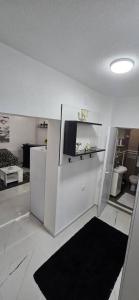 een keuken met een witte koelkast en een zwart tapijt bij Tina apartman in Vranje