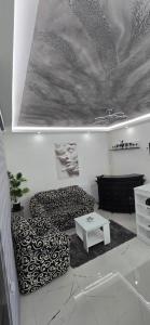 een woonkamer met een bank en een tafel bij Tina apartman in Vranje