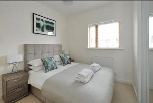 a bedroom with a bed with towels on it at Liberty Marina 2br Apartment in Portishead