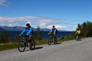 a group of people riding bikes down a road at Svensby Tursenter in Svensby