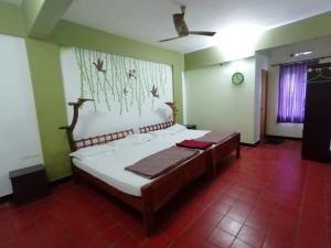 a bedroom with a large bed in a room at Tapovan Fruitopia in Sultan Bathery