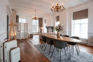 een woonkamer met een tafel, stoelen en een bank bij Hotel het Oude Raadhuis in Castricum