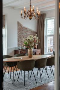 een eetkamer met een tafel met stoelen en een kroonluchter bij Hotel het Oude Raadhuis in Castricum +39 foto's