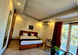 a bedroom with a bed and a large window at Stays - NH 8 in Gurgaon