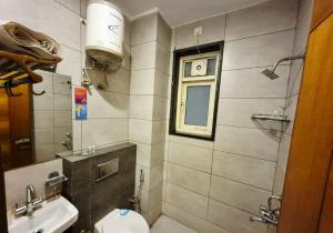 a bathroom with a sink and a toilet and a window at Stays - NH 8 in Gurgaon +20 photos